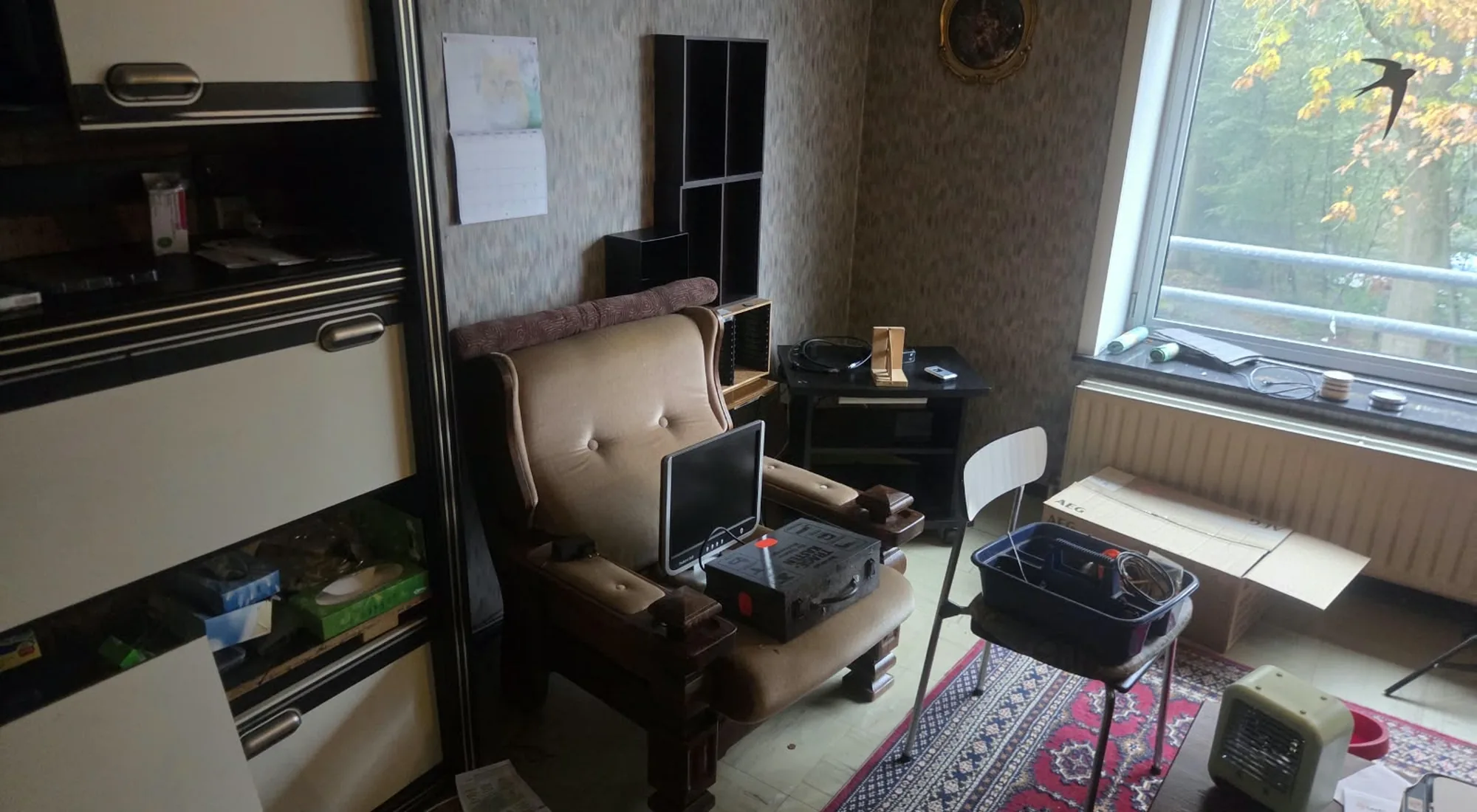 Appartement leegmaken: woonkamer met een zetel die nog weg moet
