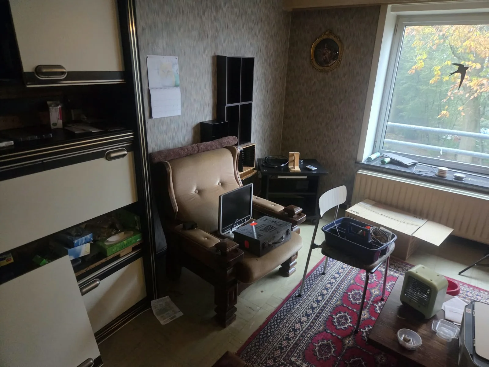 Appartement leegmaken: woonkamer met een zetel die nog weg moet