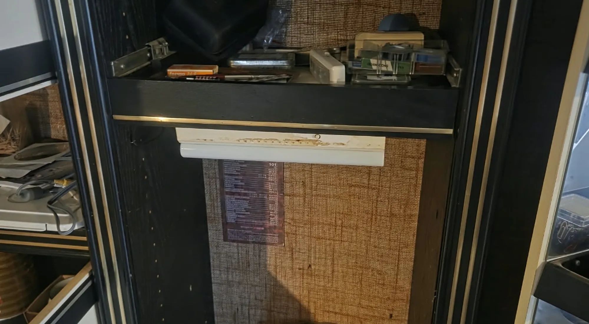 Appartement leegmaken: zwarte kast met de laatste spullen op de planken